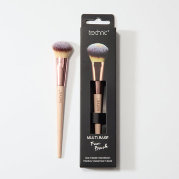 2 multi-base face brushes on a white background. 1 is in its original packaging which is black and has an image of he brush on the front, and the other is out of the packaging.