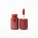 Red lip and cheek tint with applicator on a white background