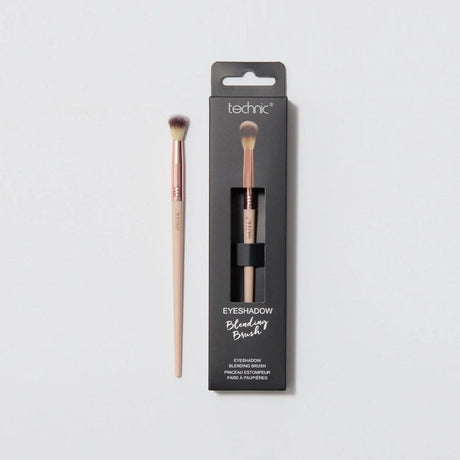 An eyeshadow blending brush in the packaging next to one out of the packaging on a white background.